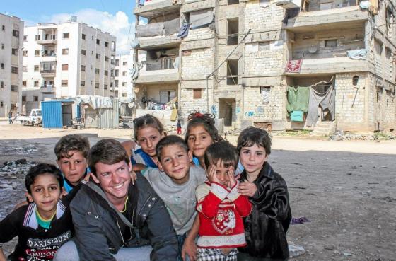 L’humanitaire français originaire de Bretagne Pierre Le Corf entouré d'enfants à Alep. D. R.